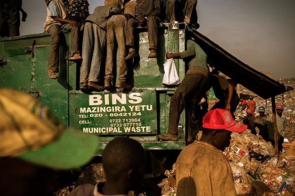 Men pick through a waste bin and the garbage pile at the 30-acre Dandora dump in Nairobi, Kenya, in a search for food scraps and salable refuse. A controversial effort is under way to relocate the dump. Image by Micah Albert. Kenya, 2012. Media file: Dandora-5_2.jpg