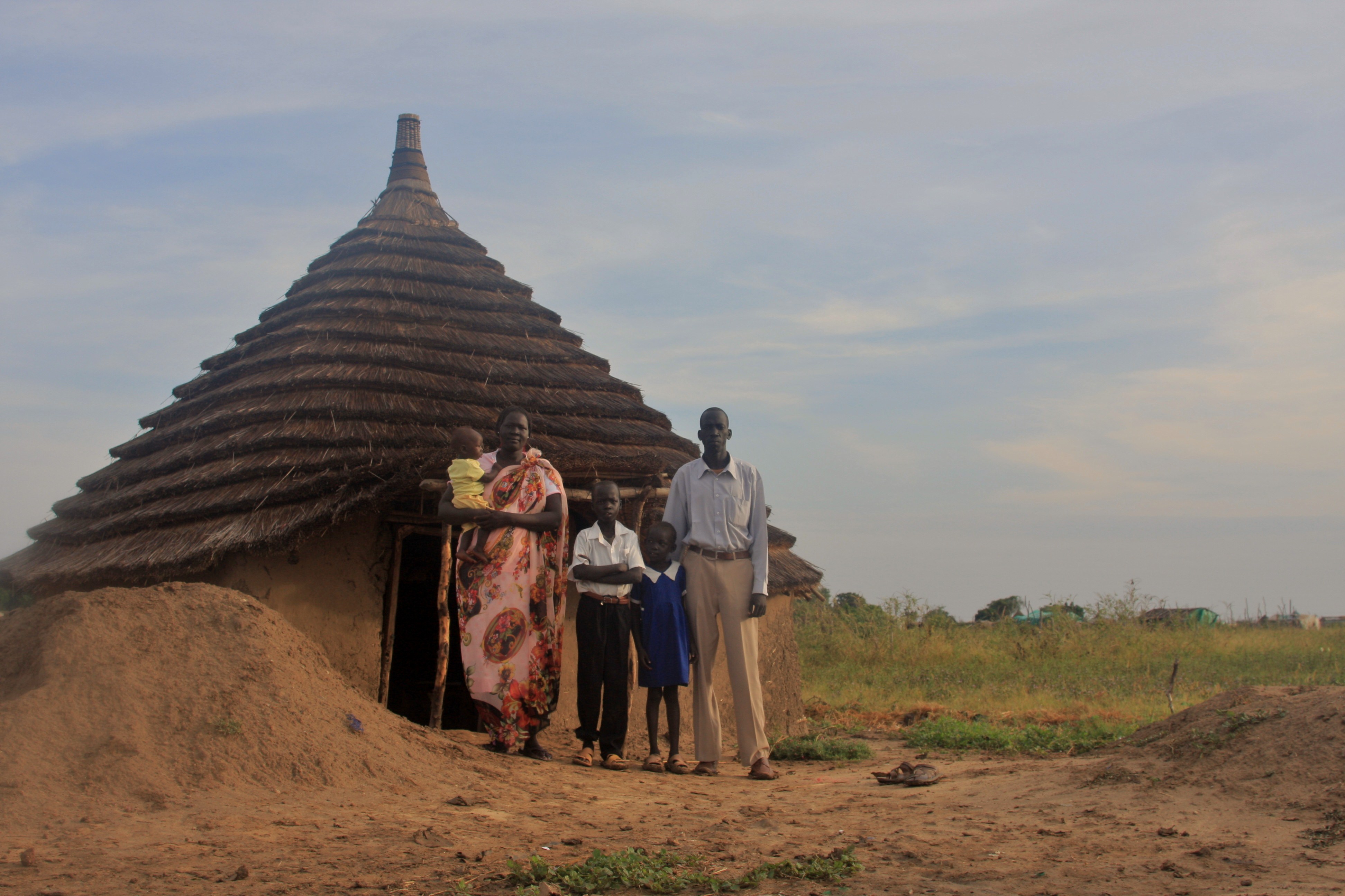 Francis Nyok Koryom and his family outside the tukul they built after the 2008 Abyei violence destroyed their home. Image by Rebecca Hamilton. Sudan, 2010.