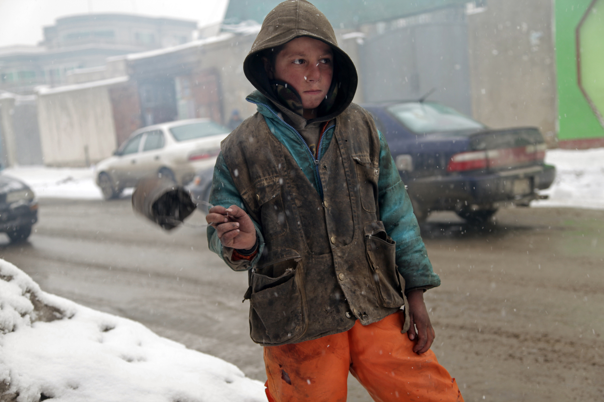 A young boy touts spand from an old can (called a "spandee"). Spand is an herb found in markets across the country. When it’s burned, its smoke is believed to ward off misfortune and evil spirits. Image by Seamus Murphy/VII. Afghanistan, 2012. Media file: Kabul-Afghanistan-spandee-young-boy.jpg