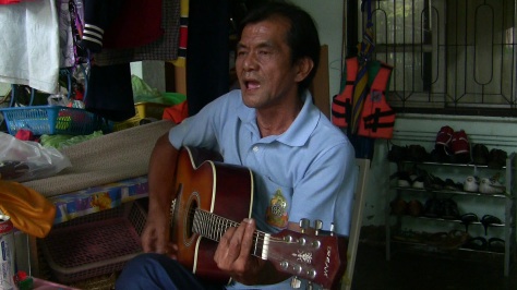 Kriengsak Sathienwatana (Toy) plays music by the Scorpions, and discusses the elections. Image by Jesse Hardman. Thailand, 2011. image