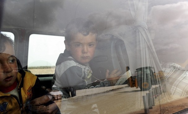 Syrian refugee children look out of a bus as they arrive to Oncupinar refugee camp in Kilis, Turkey. Image by Freedom House, Flickr. Turkey, 2012. Media file: SyriaRefugeesChildrenFlickr.jpg