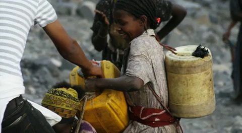 A girl carries jerry cans of water in Ethiopia. Image by Alex Stonehill. Ethiopia, 2008. A girl carries cans of water. Image by Alex Stonehill. Ethiopia, 2008.