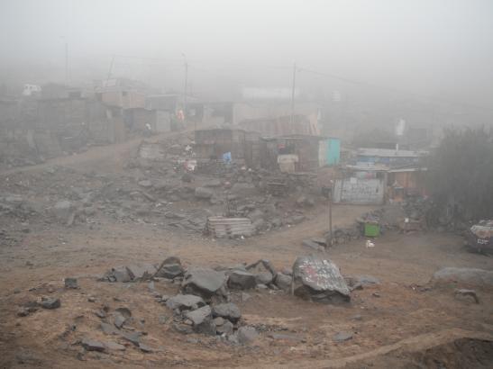 The view from the Santa Rosita Kindergarten, of the Lima shantytown of Huaycan, sprawling up the western slopes of the Andes. The sea mist sweeping in from the Pacific Ocean normally does not reach Huaycan. When it does, the temperature plummets and the humidity goes through the roof. It almost never rains here and there are plans afoot to extract water from the mist using giant nets. Image by Simeon Tegel. Peru, 2012. Media file: Waterless Lima 051.jpg