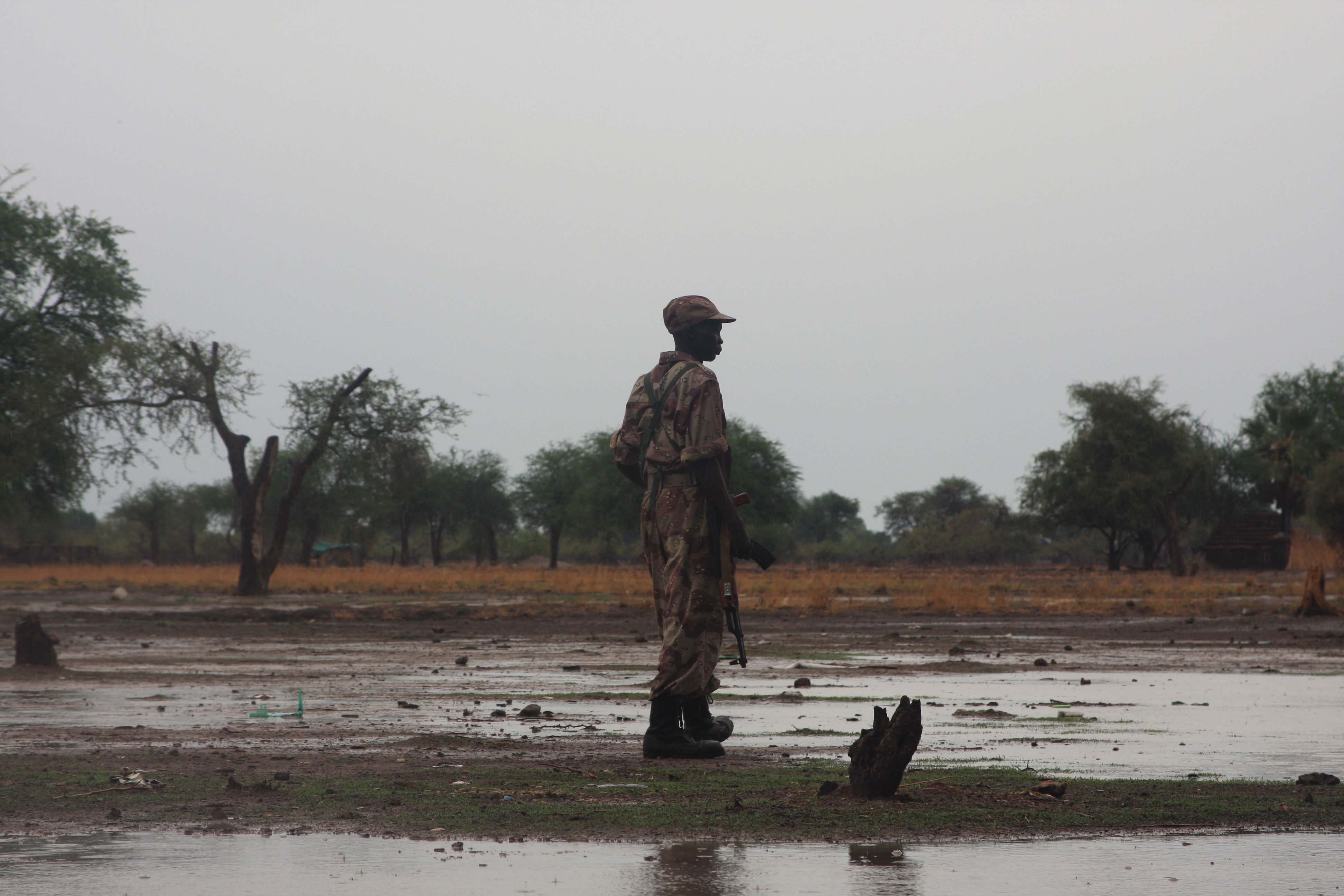 A soldier of the southern government’s SPLA stands guard in front of an area of Turalei where Abyei’s frightened population have fled to. Image by Rebecca Hamilton. Sudan, 2011.