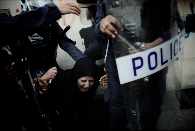 A Bahraini Shiite protester reacts as she is detained by riot police during an anti-government demonstration in the center of the capital Manama on September 21, 2012. (MOHAMMED AL-SHAIKH/AFP/Getty Images) Media file: bahrain_shiite_protest.jpg