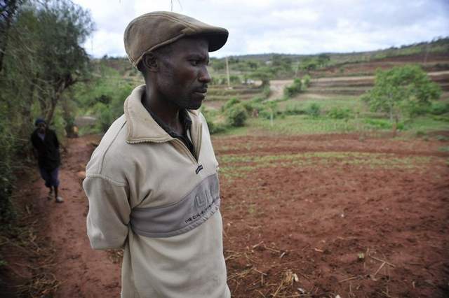 Farmer Victor Mutua shows how the drought ruined his crops. Mutua, who farms 20 acres, says he’d be willing to try genetically modified seeds. Image by Riccardo Gangale for the Des Moines Register. Kenya, 2010.