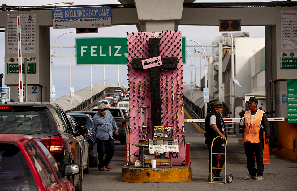 A cross with the pink sign “Ni Una Más” or “Not One More” sits at the Paso del Norte International Bridge, which connects Juárez and El Paso, Texas. “Ciudad Juárez has been a very resilient city battered by gender violence,” says Verónica Corchado, director of the Municipal Institute of Women in Juárez. “From 1993 — when they started registering the cases — until today, around 1,700 women have been murdered as a result of gender violence.” Local academics and activists have helped compile this data. Image by Erika Schultz. Mexico, 2020. A cross with the pink sign “Ni Una Más” or “Not One More” sits at the Paso del Norte International Bridge, which connects Juárez and El Paso, Texas. “Ciudad Juárez has been a very resilient city battered by gender violence,” says Verónica Corchado, director of the Municipal Institute of Women in Juárez. “From 1993 — when they started registering the cases — until today, around 1,700 women have been murdered as a result of gender violence.” Local academics and activists have helped compile this data. Image…