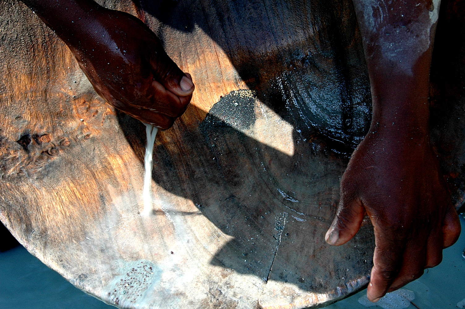 Miners sift ground rock in a wooden plate called a batea to find specks of gold in La Toma, Cauca. Image by Nadja Drost. Colombia, 2011. image