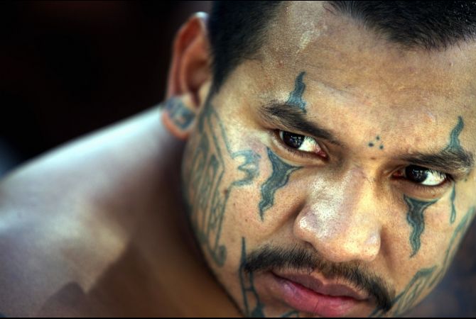 An arrested member of the Mara Salvatrucha gang faces the press in El Salvador's capital of San Salvador. Image by Yuri Cortez. Media file: el_salvador_mara_2012_05_21_a.jpg