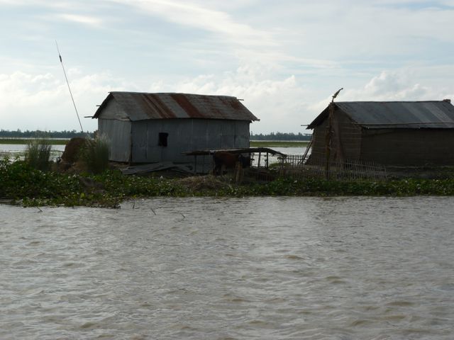 This village sits tenuously on a char, or temporary island, in the middle of the massive Jamuna River delta in northern Bangladesh. High water flows from India and the Himalayans poses a constant threat during monsoon season. Residents frequently have to suspend their beds and food from the ceilings to get above the floodwaters, often living like that for weeks. In addition to water, snakes are a problem. 1