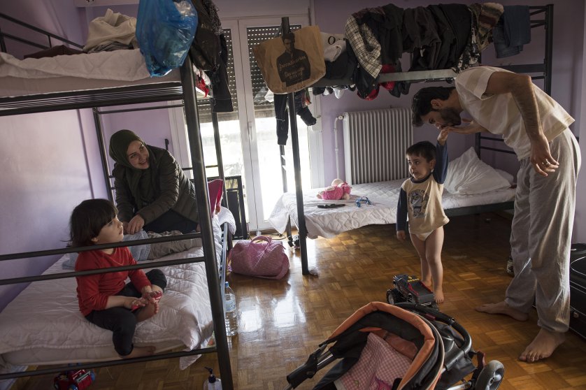 Syrian refugee, Taima, prepares to take her 6-month-old daughter, Heln, for a visit to the Acropolis, while her husband, Muhannad Abzali, 28, jokes around with their other child, Wael, 3, at the temporary apartment they are staying at in Athens. Image by Lynsey Addario. Greece, 2017. Syrian refugee, Taima, prepares to take her 6-month-old daughter, Heln, for a visit to the Acropolis, while her husband, Muhannad Abzali, 28, jokes around with their other child, Wael, 3, at the temporary apartment they are staying at in Athens. Image by Lynsey Addario. Greece, 2017.