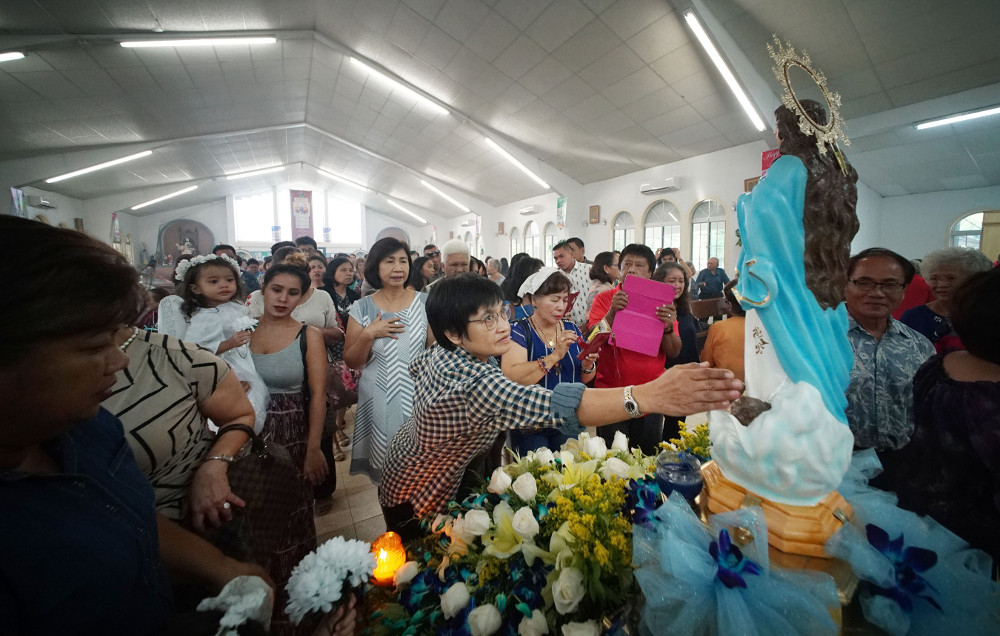 Parishioners pay their respects during a Mass held in honor of the Assumption of Our Lady in Piti, Guam. Image by Cory Lum. Guam, 2017. Parishioners pay their respects during a Mass held in honor of the Assumption of Our Lady in Piti, Guam. Image by Cory Lum. Guam, 2017.