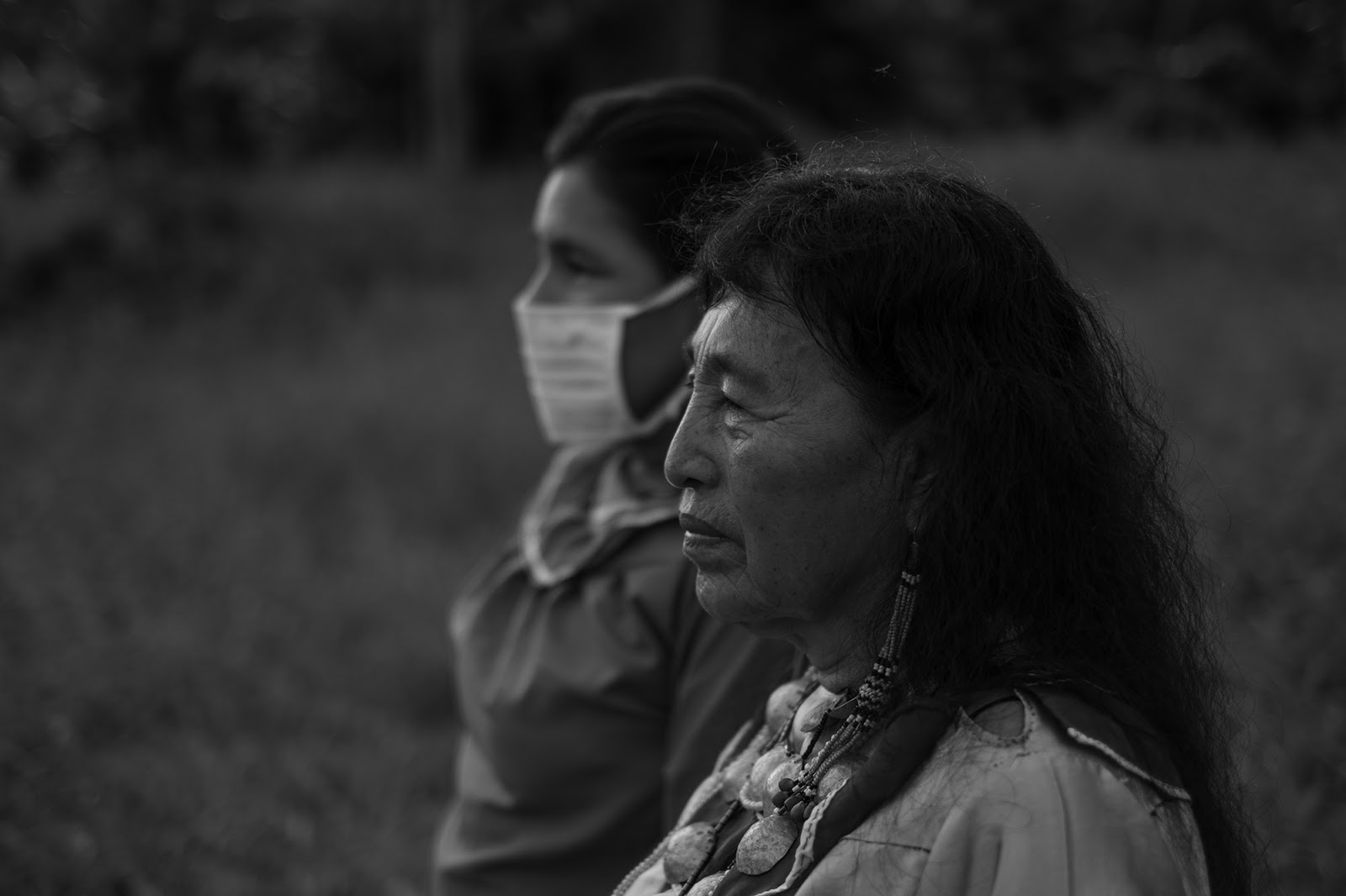 Two women; one wears a medical mask.