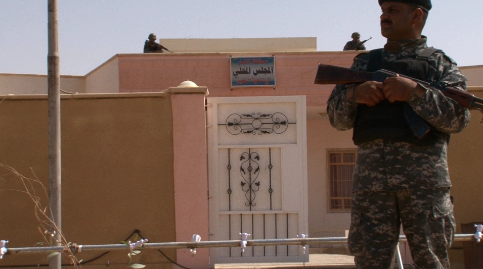 Soldiers stand guard in front of a municipal building in Nakhib, Iraq. Image by David Enders. Iraq, 2011. Media file: iraqenders.jpg