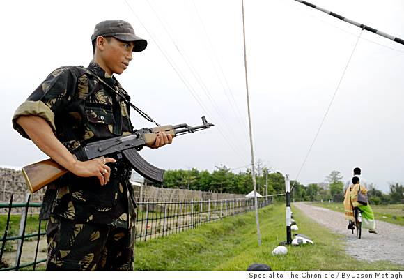 A rebel soldier guards the main gate of one of three camps designated for fighters of the National Democratic Fighters of Boroland. Media file: mn-india19_assam_p_0498648491.jpg