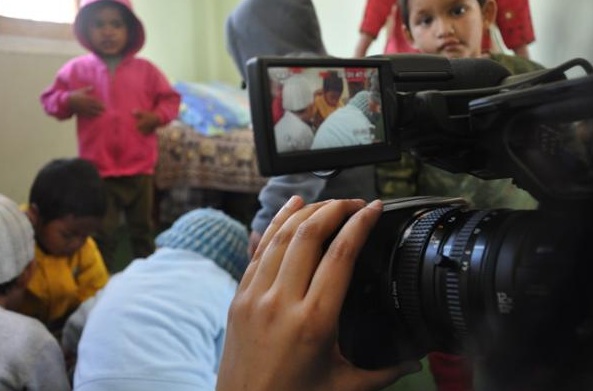 Habiba Nosheen films inside an orphanage in Kathmandu shortly after the US suspended adoptions of all children from Nepal, saying documents provided by Nepalese authorities were unreliable. The suspension left prospective adoptions by more than 70 American families in limbo. Image by Anup Kaphle. Nepal, 2011. Media file: nepal.adoption.habiba.nosheen.jpg