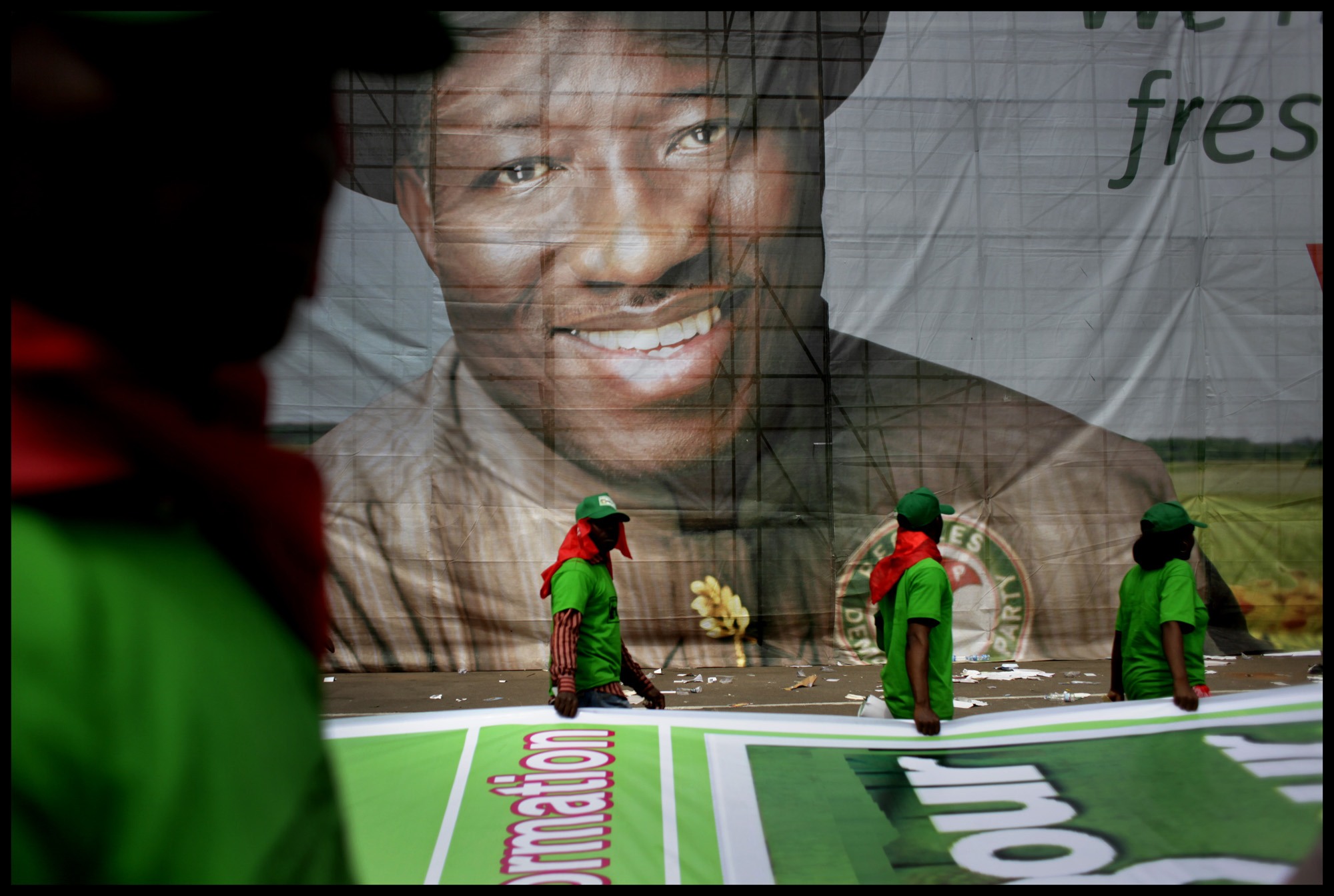 People's Democratic Party (PDP) supporters in Abuja march in front of a portrait of Nigerian president Goodluck Jonathan during the final campaign rally before presidential elections. The oil-rich nation's ruling party of 12 years faces a possible runoff. Image by Bénédicte Kurzen. Nigeria, 2011.