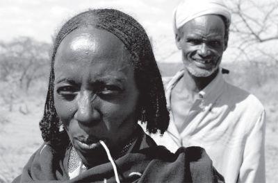 A pastoralist couple from the Borena tribe outside of Dubluck, Ethiopia. The woman makes extra money selling tea along the roadside where other pastoralists travel to a weekly market in Dubluck. 1