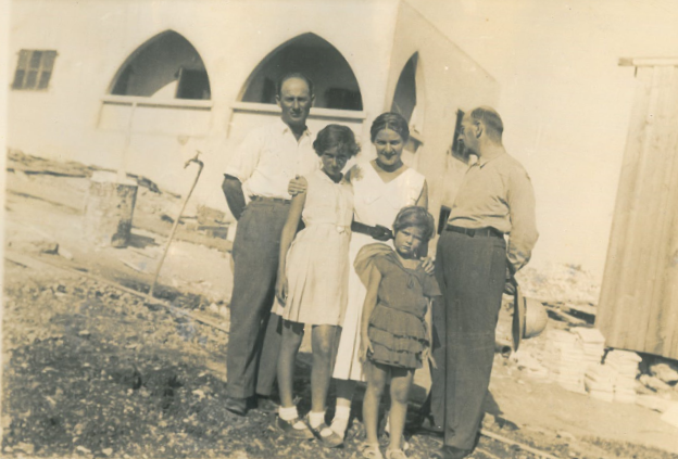 Shula Lavyel and her younger sister, Avivit, with their father (right) and his two siblings, in front of their house in Haifa being built. Image courtesy of Shula Lavyel. British Mandate of Palestine, 1935. Shula Lavyel and her younger sister, Avivit, with their father (right) and his two siblings, in front of their house in Haifa being built. Image courtesy of Shula Lavyel. British Mandate of Palestine, 1935.