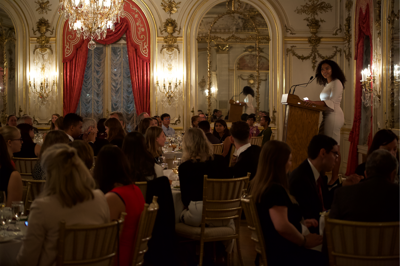 screen_shot_2019-10-21_at_2.48.02_pm.png Camila DeChalus, former Pulitzer Center reporting fellow from American University and a current grantee who works as a reporter for CQ Roll Call covering homeland security and immigration, addressed guests during the Cosmos Club dinner. Image by Claire Seaton. United States, 2019.