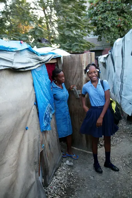Ready for school, Cynthia says good-by to her mother. Image by Jon Sawyer. Haiti, 2012. Media file: -20.jpg