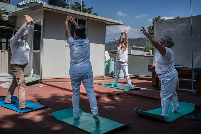 Antonieta Battista Cruz (facing the camera) leads a yoga class as part of a free community programme to combat obesity in Oaxaca. Exercise plans come with advice on healthy diets. Several participants revealed they had been diagnosed with high blood sugar or diabetes and were determined to improve their health for the sake of their families. Image by James Whitlow Delano. Mexico, 2017. Antonieta Battista Cruz (facing the camera) leads a yoga class as part of a free community programme to combat obesity in Oaxaca. Exercise plans come with advice on healthy diets. Several participants revealed they had been diagnosed with high blood sugar or diabetes and were determined to improve their health for the sake of their families. Image by James Whitlow Delano. Mexico, 2017.
