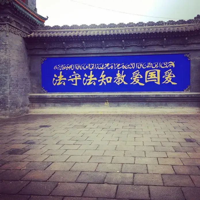 A sign in Ningxia, northwestern China, reads: "Love your country, love your religion; know the law, follow the law". Image by Alice Su. China, 2016.
