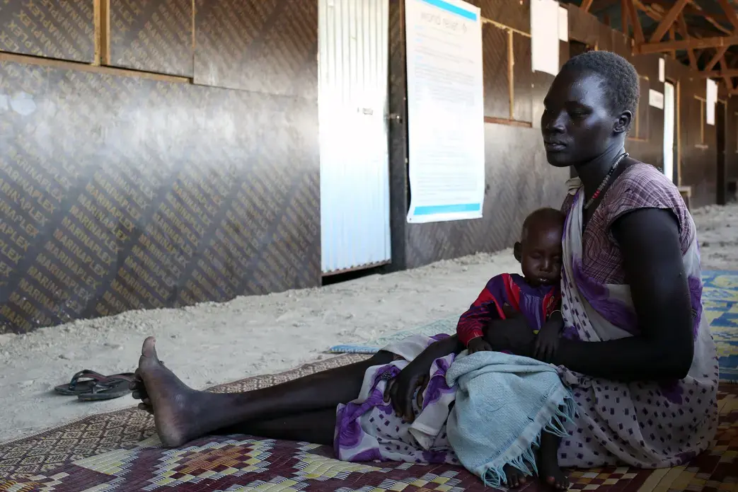 Nyabany and her daughter wait at a clinic at the U.N. base in Bentiu. Eight-month-old Nyadholi is suffering from severe acute malnutrition. Image by Cassandra Vinograd. South Sudan, 2016. Nyabany and her daughter wait at a clinic at the U.N. base in Bentiu, South Sudan, on Dec. 18, 2016. Eight-month-old Nyadholi is suffering from severe acute malnutrition. Image by Cassandra Vinograd. South Sudan, 2016.