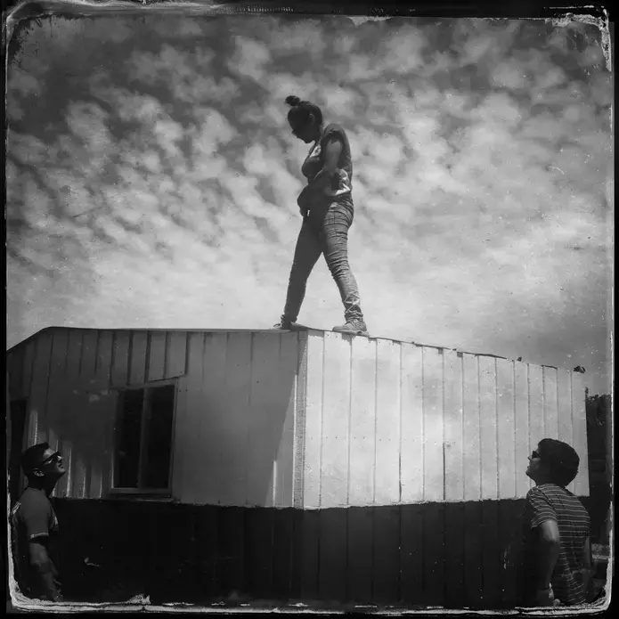 A member of non-profit organization TECHO helps build a roof in a shantytown in Santiago, Chile. Image by Jeff Kelly Lowenstein. Chile, 2013. Media file: 13_november_09_chile_00016.jpg