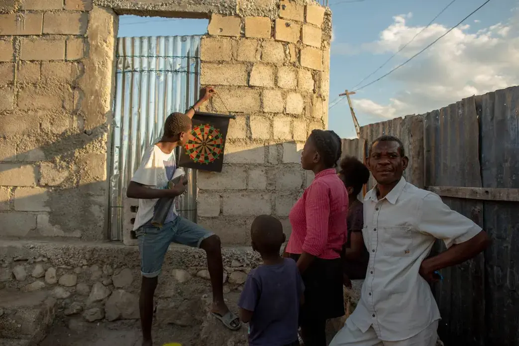 Alisma Robert, right, and children Esaie Robert, 15, Roberson Robert, 7, and Kerline Reobert, 18, standing, enjoy the evening at their home in the Canaan 3 neighborhood of greater Canaan, Haiti, January 7. Thomson Reuters Foundation. Image by Allison Shelley. Haiti, 2019. Alisma Robert, right, and children Esaie Robert, 15, Roberson Robert, 7, and Kerline Reobert, 18, standing, enjoy the evening at their home in the Canaan 3 neighborhood of greater Canaan, Haiti, January 7. Thomson Reuters Foundation. Image by Allison Shelley. Haiti, 2019.