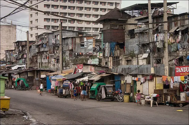 Image by Anton Zelenov, courtesy of Wikimedia Commons. A Manila street scene showing informal housing and shops.