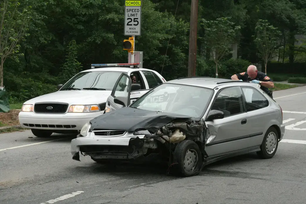 Police checking a car accident in Durham, N.C. Image by Ildar Sagdejev/Wikimedia Commons. United States, 2010. Media file: 2010-05-30_durham_police_checking_wrecked_honda_civic.jpg