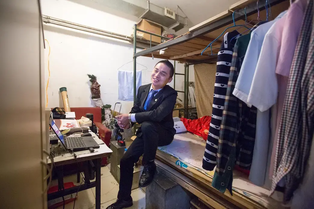 Wei Kuan, an insurance salesman, says that he lives in a basement apartment because he wants to save money for other things. He recently bought himself a tailor-made wool suit and hopes to save enough to buy a car. Image by Sim Chi Yin. China, 2014. Media file: rat_tribe_wei_kuan1.jpg