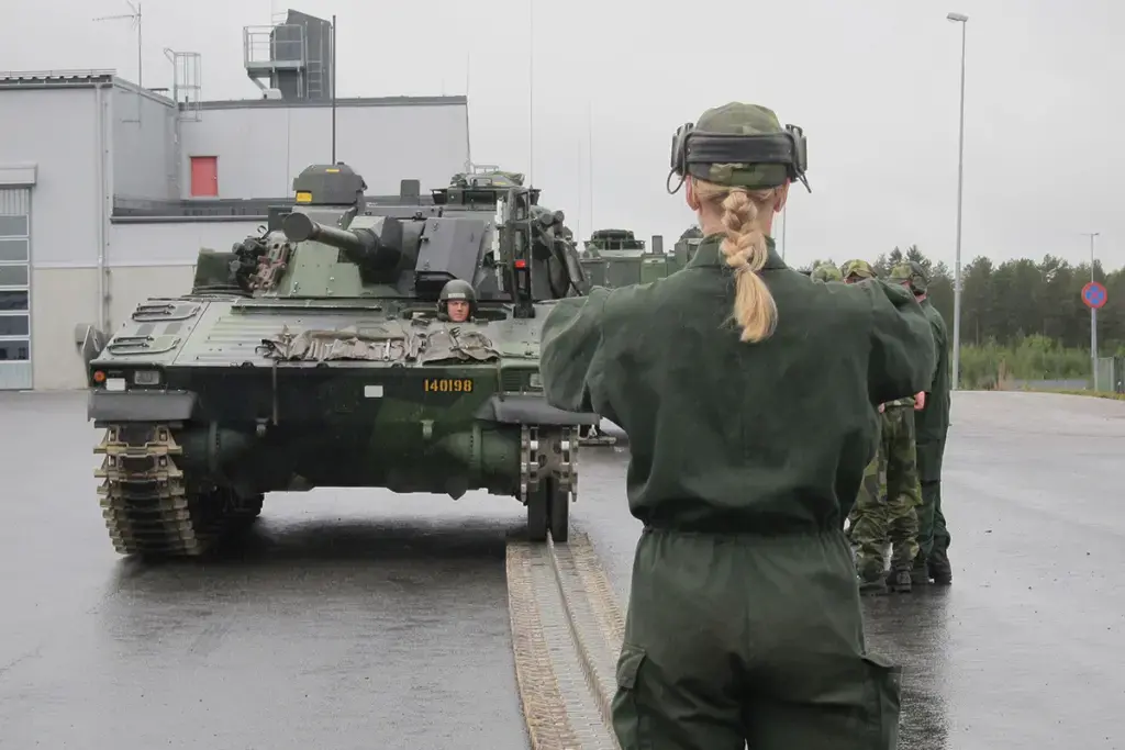 A female mechanized infantry recruit guides her crew as they learn how to repair broken vehicle tracks in Boden on September 12. Image by Teresa Fazio/Foreign Policy. Sweden, 2018.
