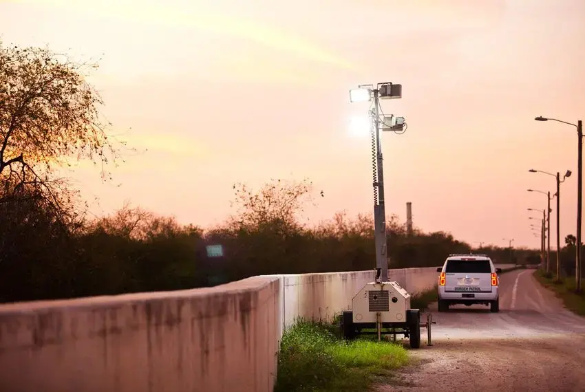 At dusk, Border Patrol agents place mobile floodlights along the levee-fence in Hidalgo County. Image by Callie Richmond. United States. At dusk, Border Patrol agents place mobile floodlights along the levee-fence in Hidalgo County. Image by Callie Richmond. United States.
