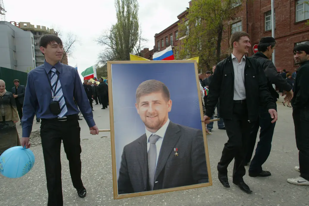 Young men carry a portrait of Ramzan Kadyrov, head of Chechnya, during May 9 Victory Day celebrations in Chechnya. Image by Musa Sadulayev. Russia, 2009.