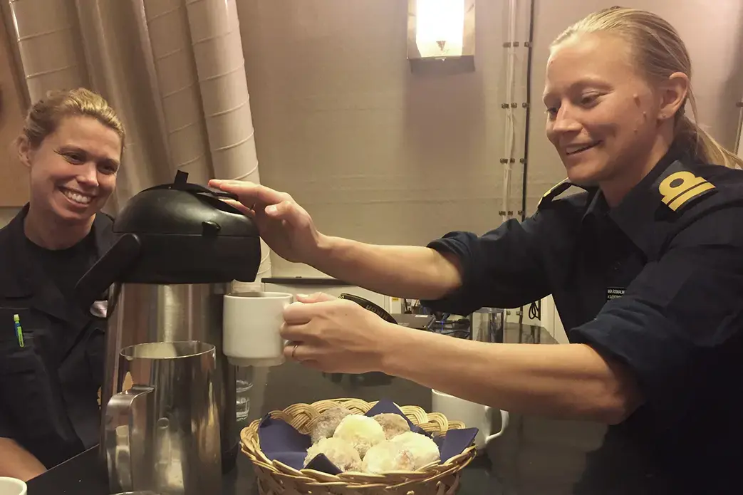 Members of GRYM, a group for women in the Swedish Navy, share coffee aboard the HMS Visby off the coast of Berga, Sweden. Image by Teresa Fazio. Sweden, 2018.