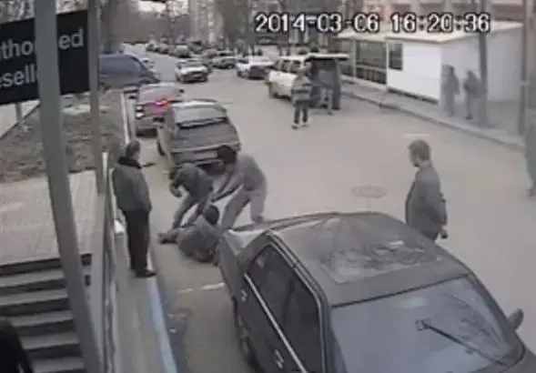 Security camera still of attack in Simferopol on Dimiter Kenarov, Pulitzer Center grantee journalist, who had been photographing a midday raid against a TV studio—part of the Associated Press network he later learned. The video footage taken by chance by the security camera was later traced and uploaded on YouTube by Ukrainian journalists. Ukraine, 2014. Media file: attack_on_dimiter.jpg