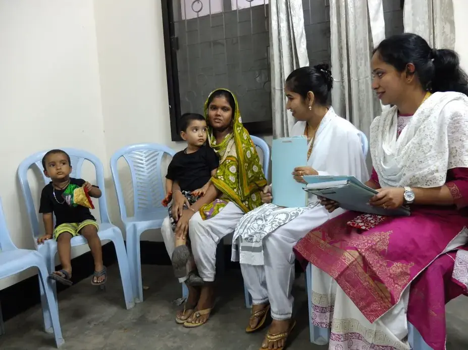 Mohommad Mustakim and his mother talk with researchers as part of a study of the rotavirus vaccine in Dhaka, Bangladesh. Mohommad got sick with rotavirus diarrhea even after getting the vaccine. Image by Carina Storr. Bangladesh, 2016. Media file: mohommad_and_family.jpg