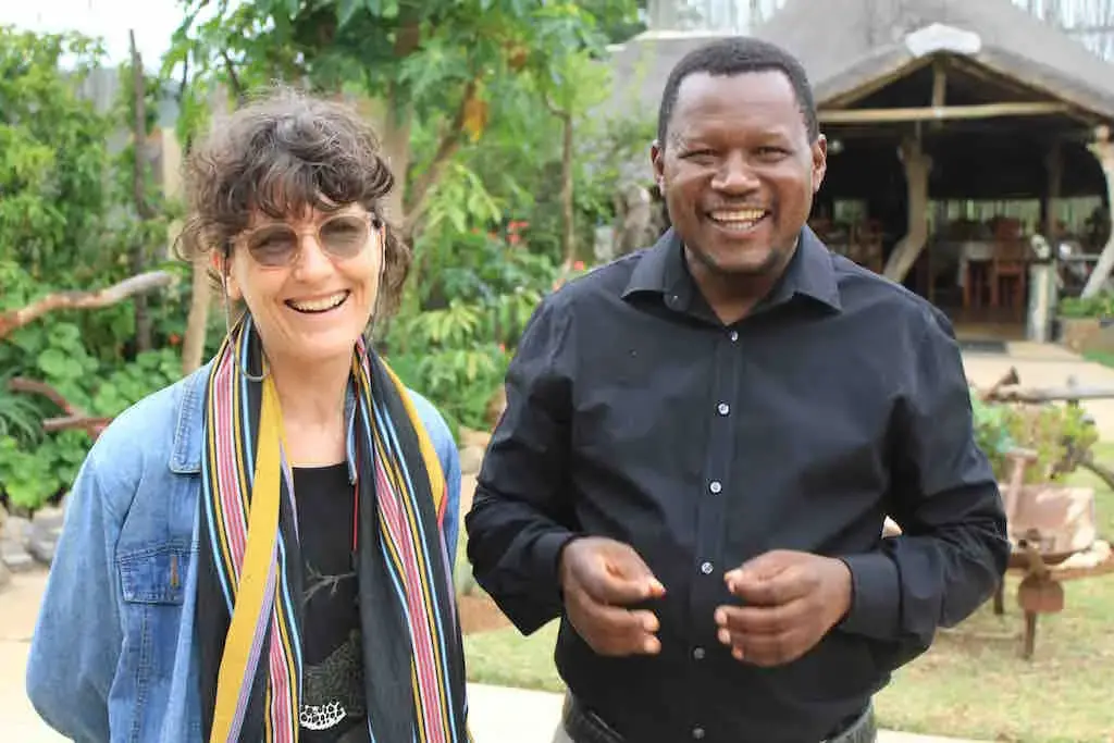 In the field: Journalist Michelle Nel (left) with Pastor Solly Mhaule, a community elder who believes the Public Protector needs to investigate the MalaMala land deal. Image by Dennis Scully. South Africa, 2019. In the field: Journalist Michelle Nel (left) with Pastor Solly Mhaule, a community elder who believes the Public Protector needs to investigate the MalaMala land deal. Image by Dennis Scully. South Africa, 2019.