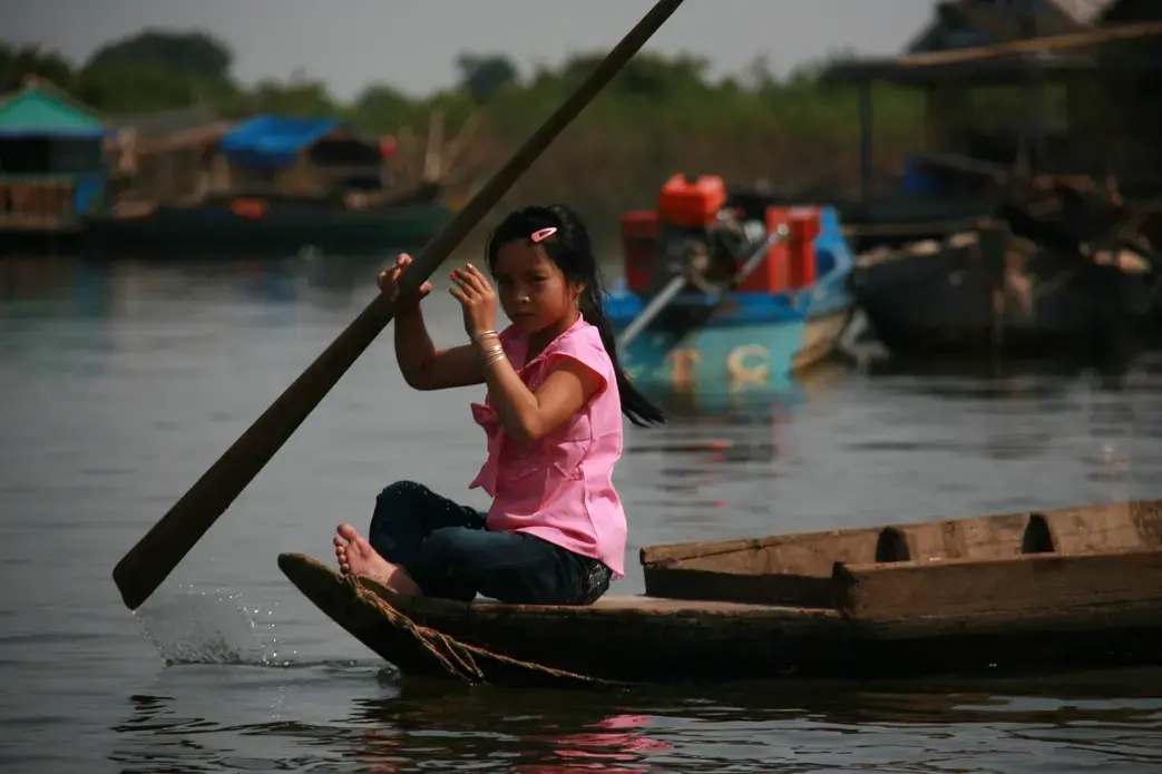 A girl paddles her way through a floating village on Lake Tonle Sap. Image by Chris Berdik. Cambodia, 2014. Media file: img_9428.jpg