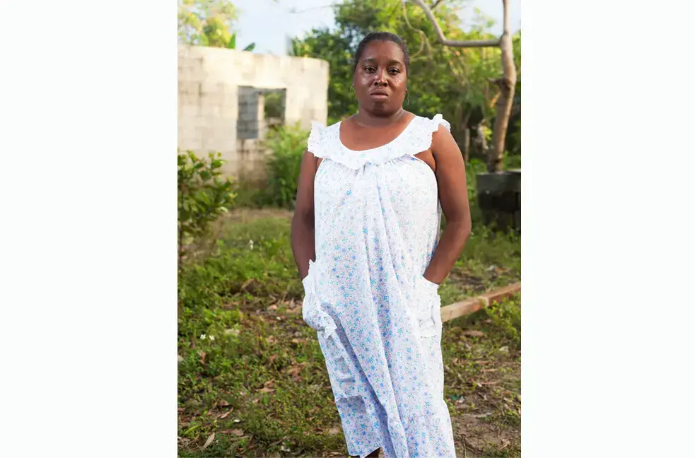 Ana Vilma Batiz stands outside of her home in Triunfo de la Cruz, Honduras. Image by David Rochkind. Honduras, 2013. Media file: ana.jpg