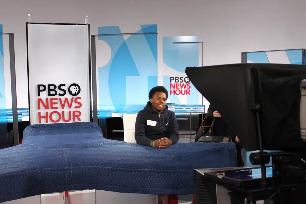 A student from Hart Middle School in Washington, DC reads from a teleprompter on the set of PBS Newshour as part of a field trip led by Pulitzer Center and PBS Newshour education staff. Image by Kim Pate. United States, 2018. Media file: img_5856_1.jpg
