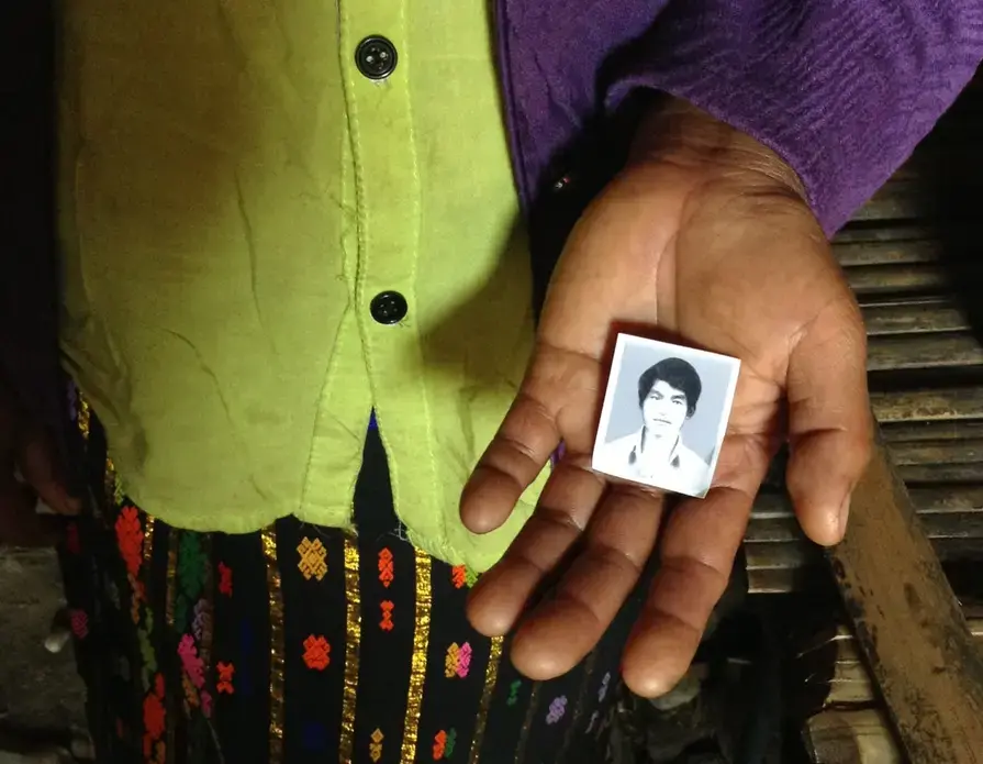 The wife of Lahpai Gam, an ethnic Kachin man arrested and allegedly tortured by Burmese security forces, holds the only known photograph of her husband. Image by Jason Motlagh. Burma, 2013. Media file: image.jpg