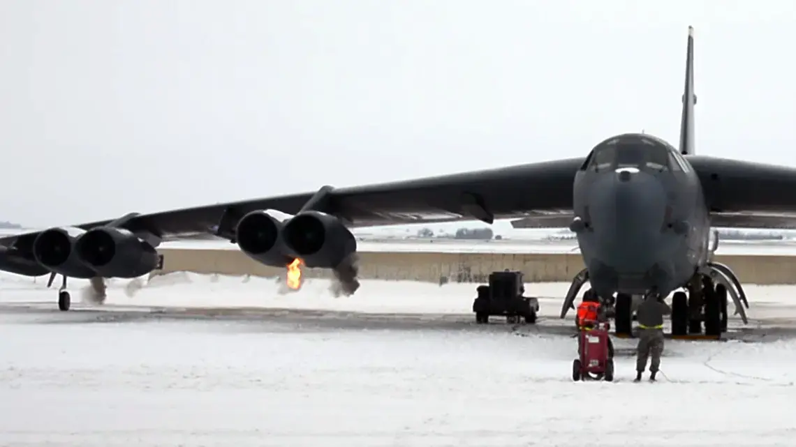 Flames and smoke burst from a B-52H’s aging jet engines, as they roar to life with the help of eight explosive charges. The method was developed during the Cold War to give the bomber a quick kick-start in a crisis. Image by Jamie McIntyre. United States, 2016. Jet flames