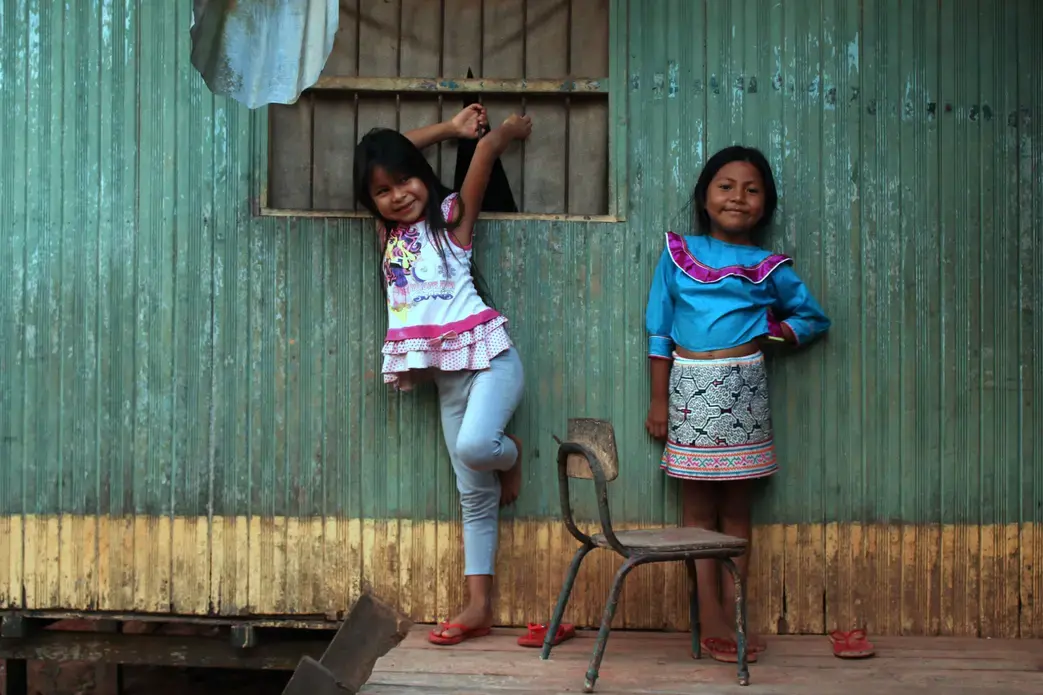 Angi and Sophia, Karina's nieces, pose against a wall of their home in Pucallpa. Image by Natalie Hutchison. Peru, 2017.