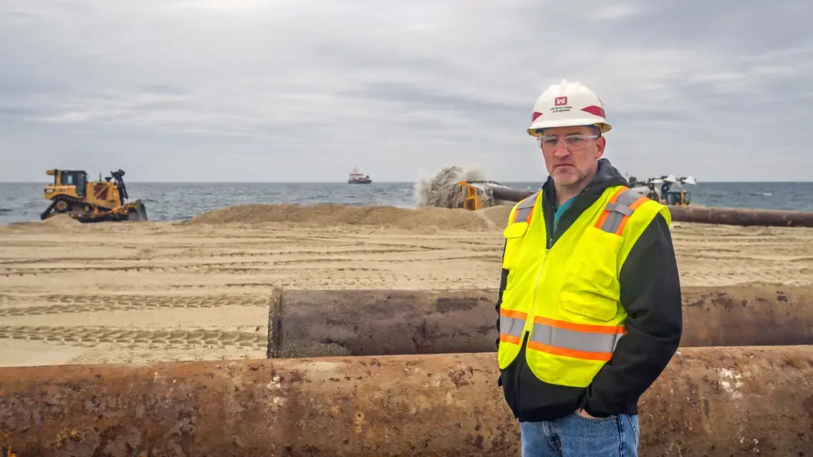 Jason Shea is the project manager for the beach renourishment initiative at Sea Bright. The dredge ship Magdalen is on the horizon. Image courtesy of NJ Spotlight. United States, undated. Jason Shea is the project manager for the beach renourishment initiative at Sea Bright. The dredge ship Magdalen is on the horizon. Image courtesy of NJ Spotlight. United States, undated.