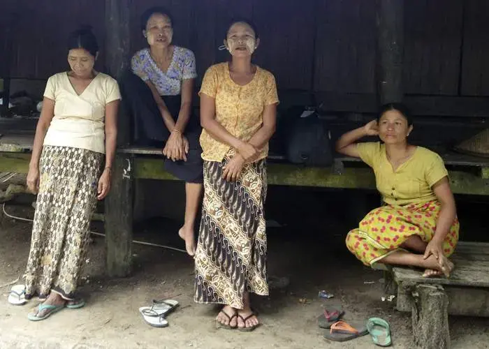 Hla Ohn May, centre, has had to take what work she can as a labourer since selling her land. She says she was never paid the amount she was promised. Image by Michael Peel. Myanmar, 2016. Media file: myanmar.jpg