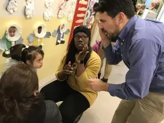 Egan was negotiating between a parent and a teacher. The girl accidently scratched herself during the day, and Egan was asking the girl questions in Spanish. Image by Thea Gu. United States, 2017.