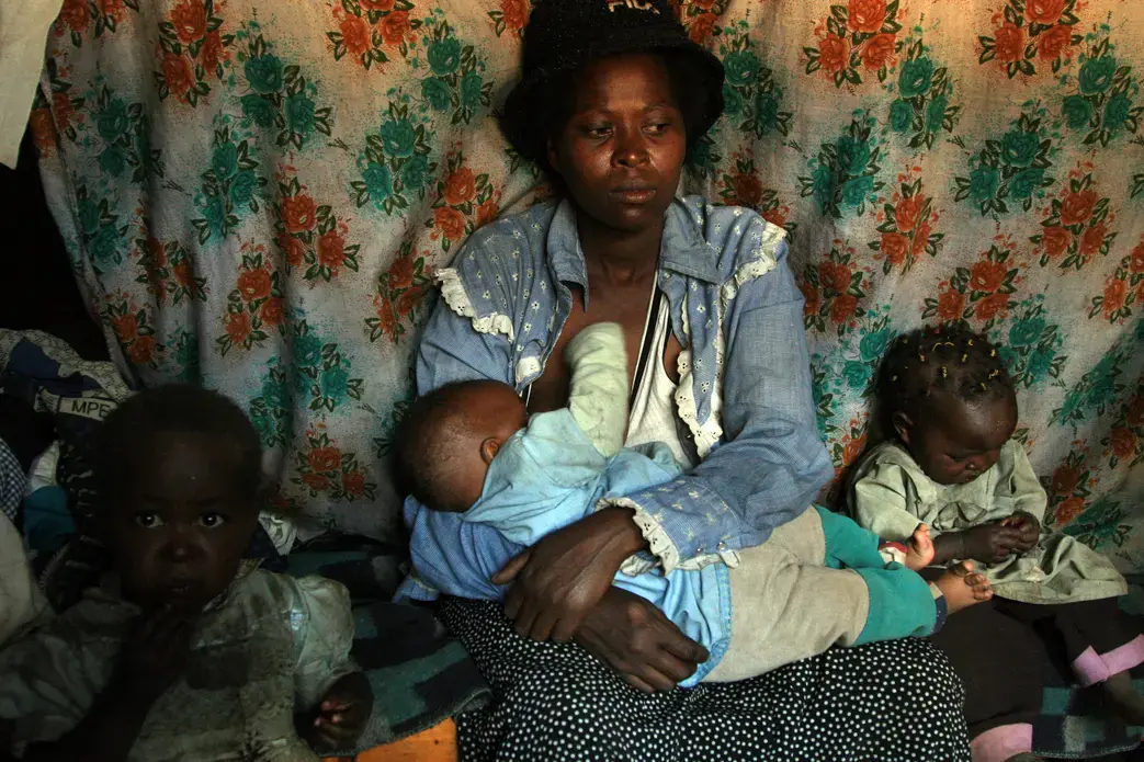 Mary Wanza, a single-mother in the Nairobi slum of Korogocho, collects discarded bottles to recycle and make a little money to care for her children. She gave birth to her first of seven children at age 15. Since then, she said she has never made enough money to buy contraceptives. Her priority is to feed her children. Image by Kenneth R. Weiss. Kenya, 2010. Media file: korogochomother.jpg